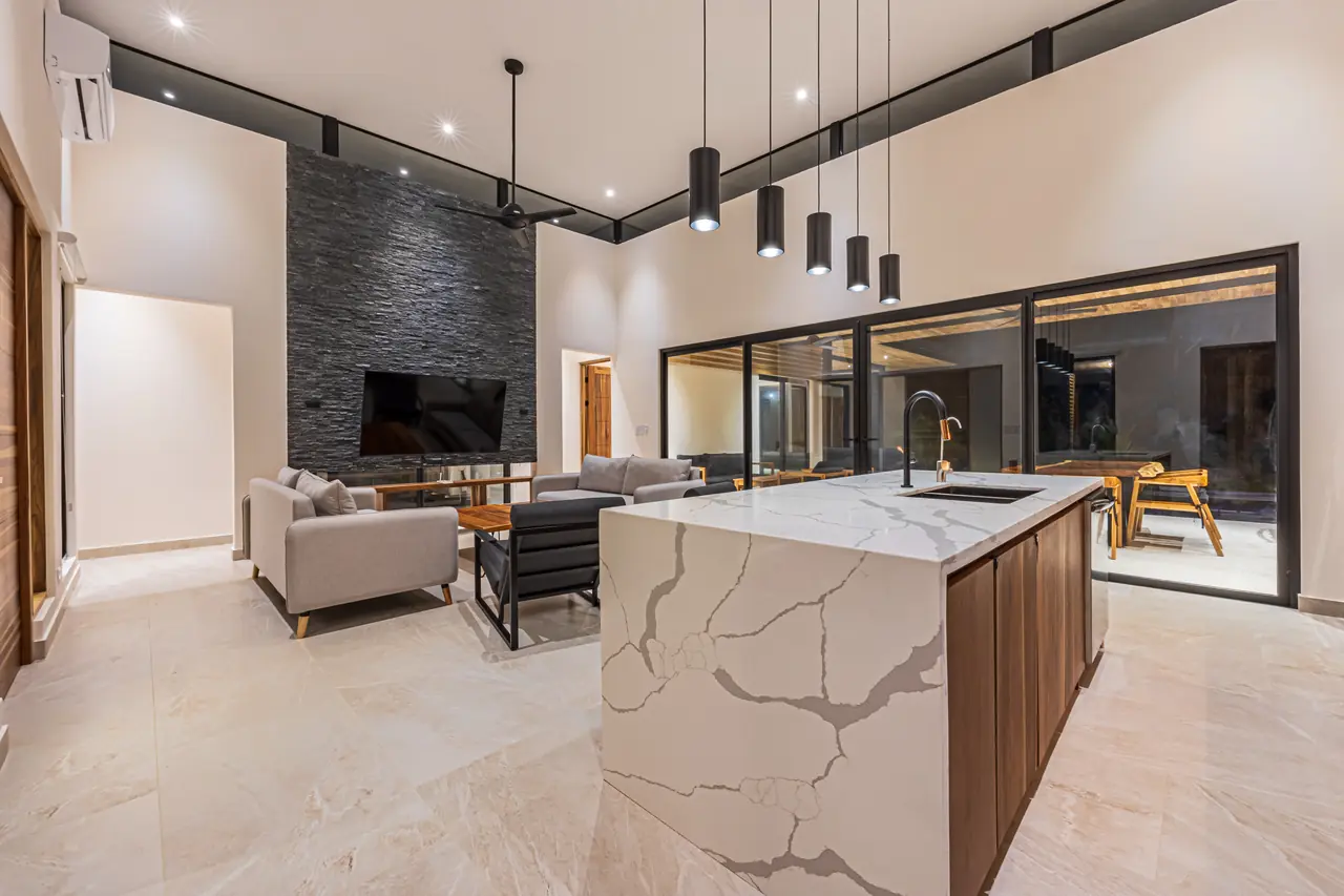Living area with quartz waterfall island and stone fireplace wall