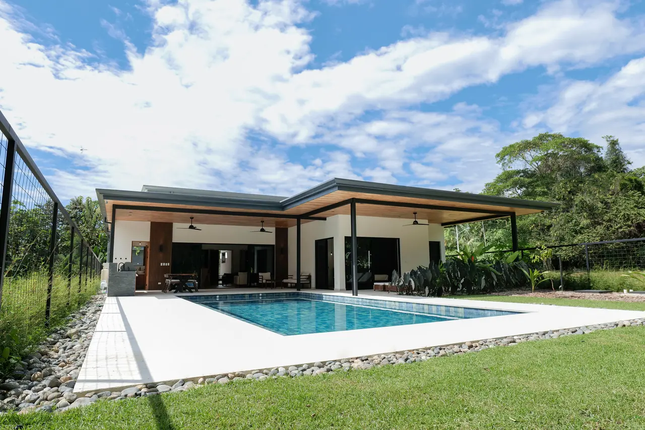 The full parcel — lawn, pool and house from the rear boundary