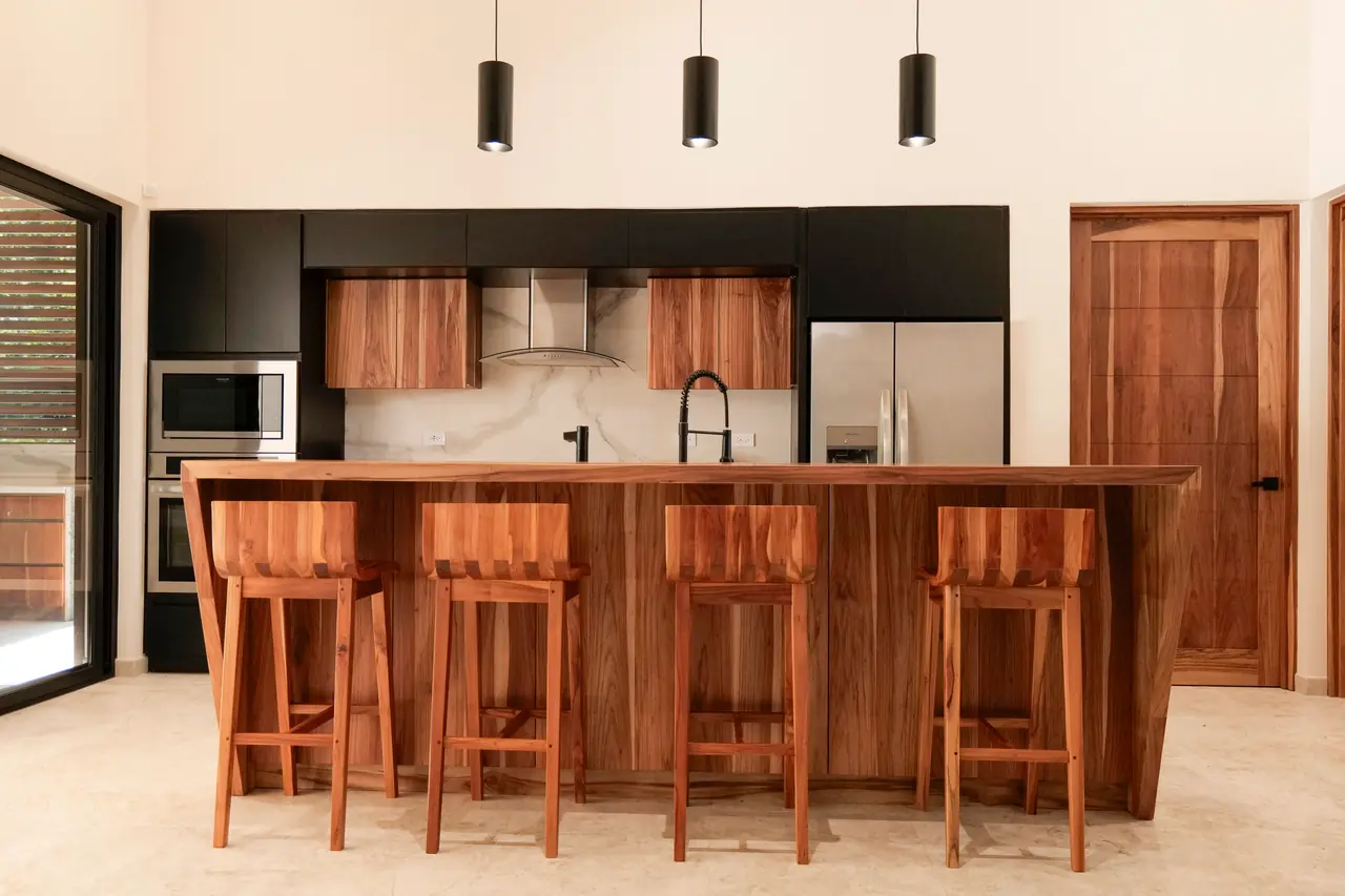The full kitchen run — hardwood cabinetry and stone splashback