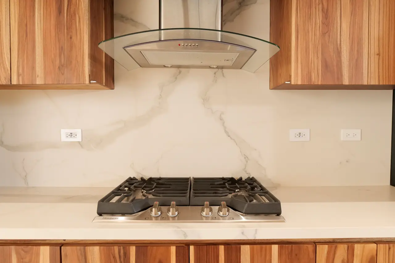 Gas cooktop set into the stone counter and book-matched splashback