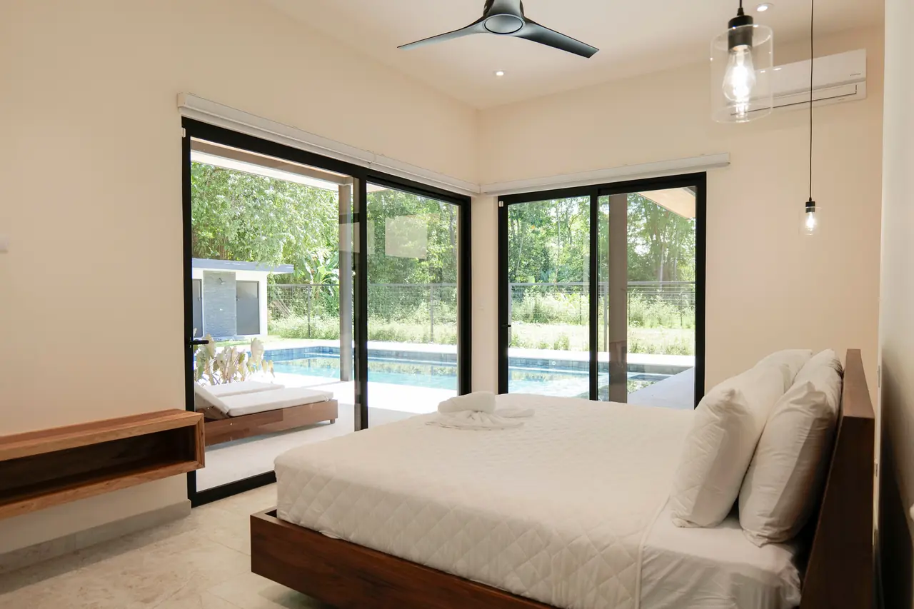 Primary bedroom with the pool framed in full-height glazing