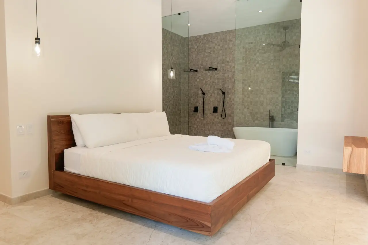 Primary suite with its open ensuite behind the bed