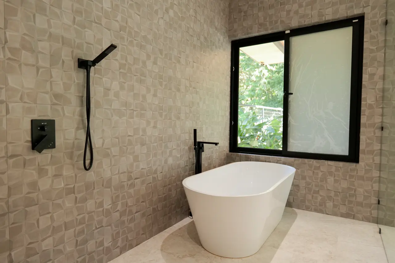 Freestanding tub against the tiled feature wall