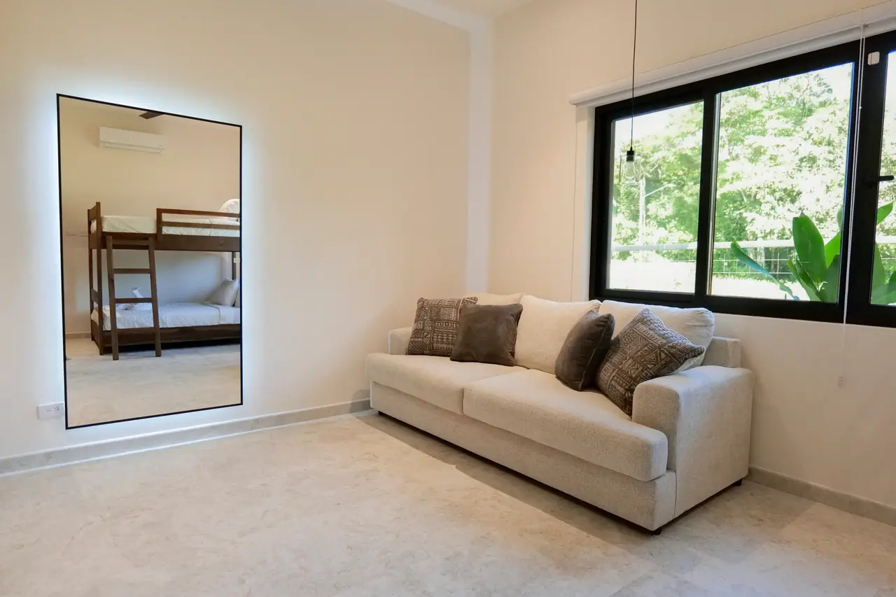 Bunk room sofa and full-height window to the garden
