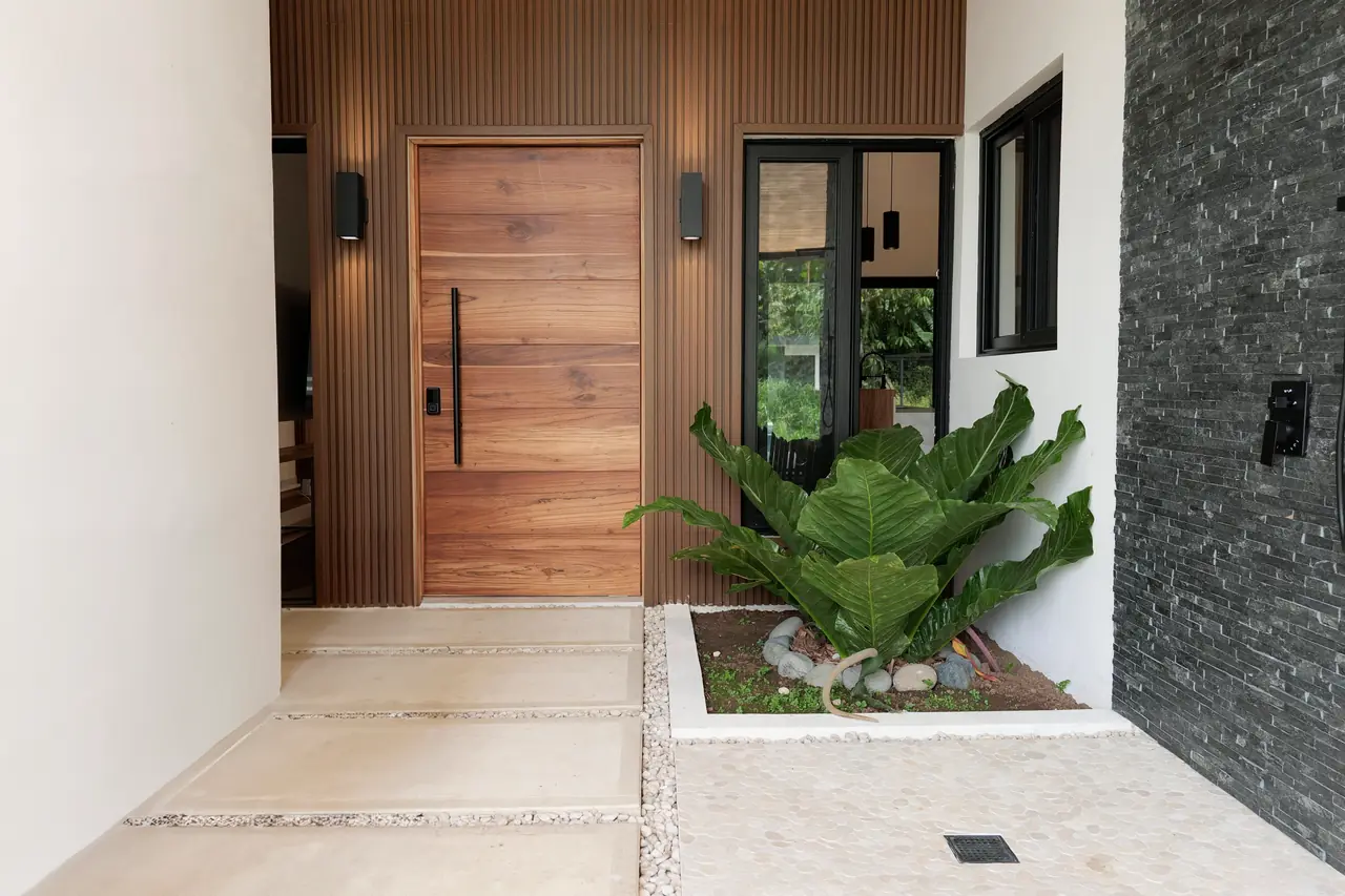 Front entry — hardwood door, slatted screen and stone wall