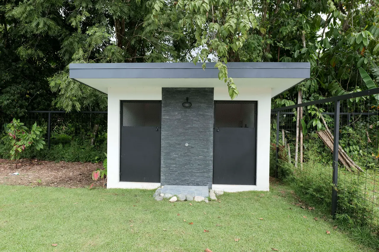 Detached outbuilding and outdoor shower at the garden edge